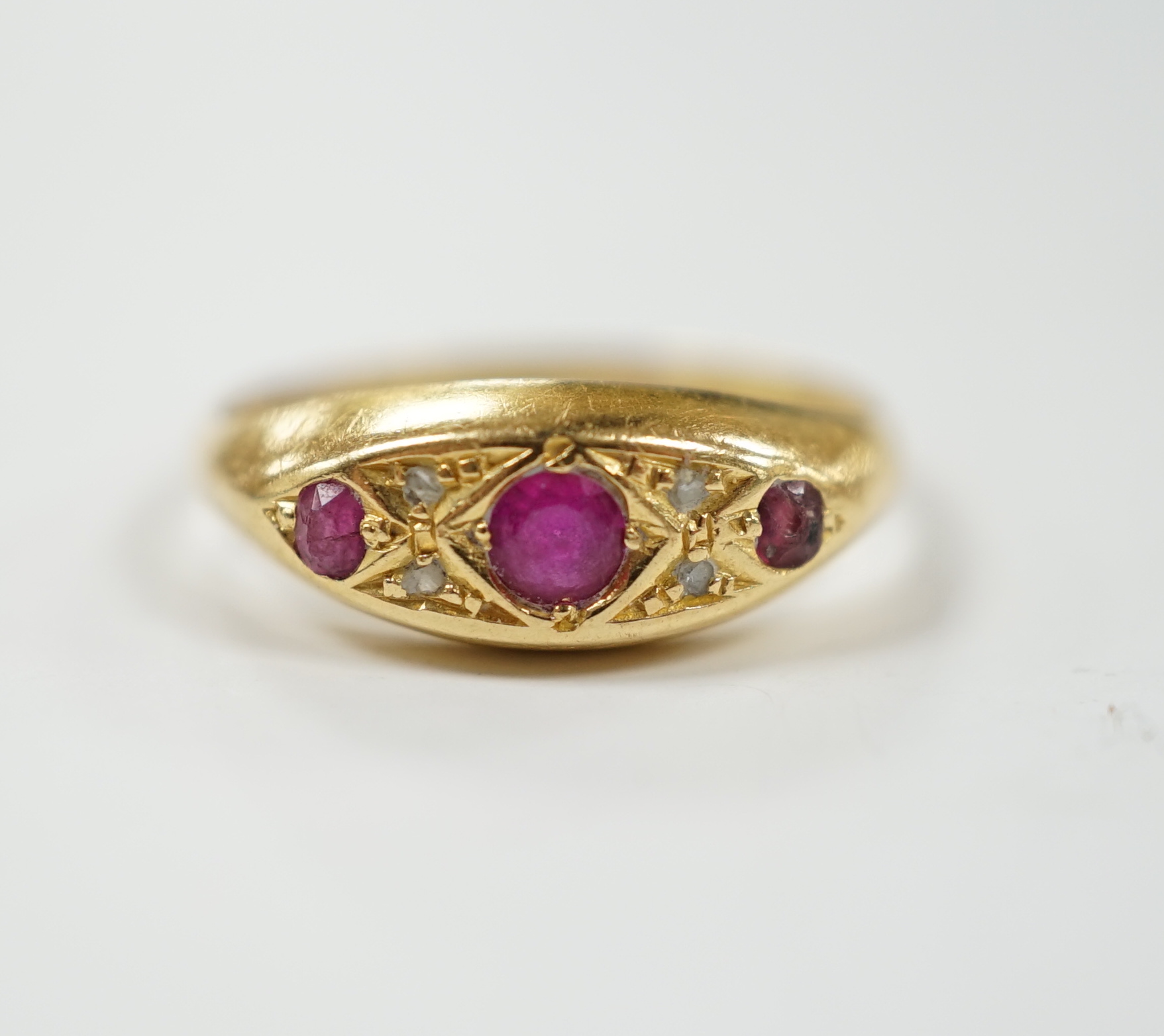 A George V 18ct gold, three stone ruby and four stone diamond chip set ring, size K, gross weight 2.4 grams.